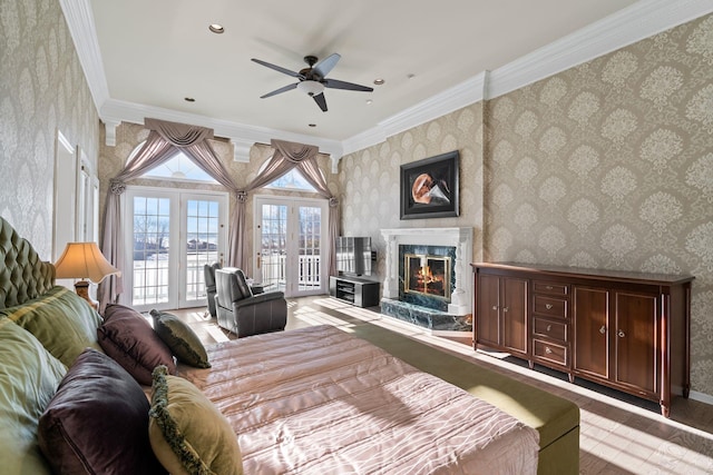 bedroom featuring french doors, ornamental molding, access to outside, ceiling fan, and a premium fireplace