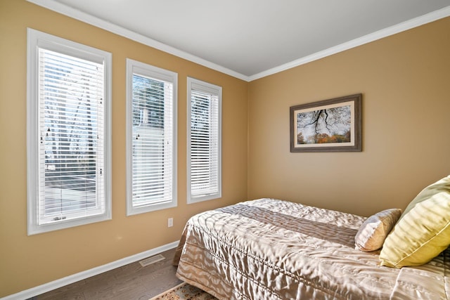 bedroom with dark hardwood / wood-style flooring and ornamental molding