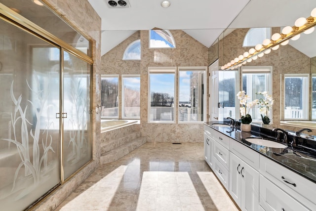 bathroom featuring tile patterned floors, a washtub, vanity, and lofted ceiling