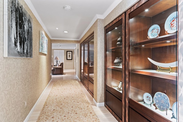 hall with light hardwood / wood-style floors and ornamental molding