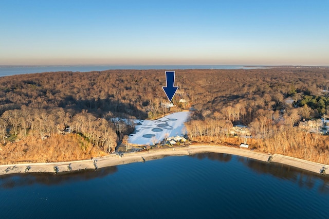 aerial view at dusk featuring a water view