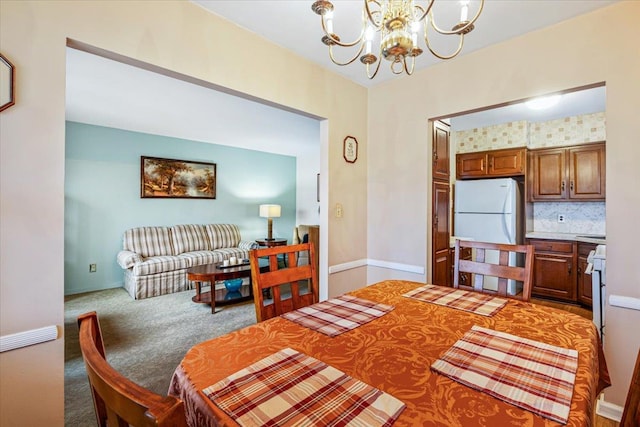 dining area featuring carpet floors and an inviting chandelier