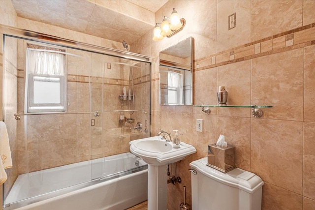 bathroom featuring shower / bath combination with glass door, tile walls, and toilet