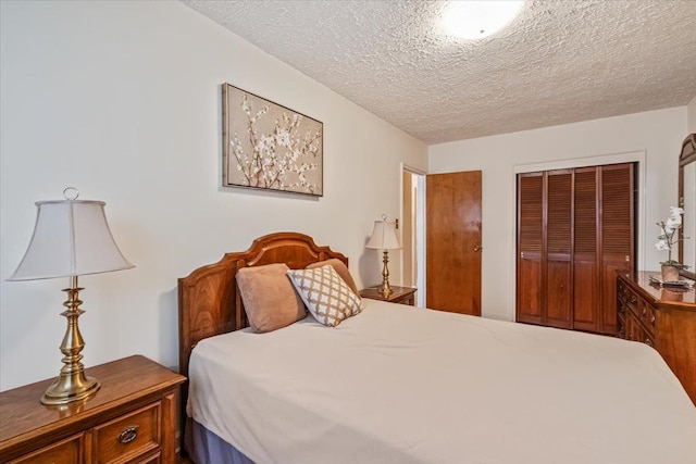 bedroom with a textured ceiling and a closet