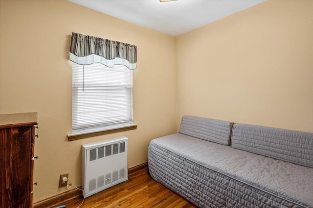 living area with hardwood / wood-style floors and radiator