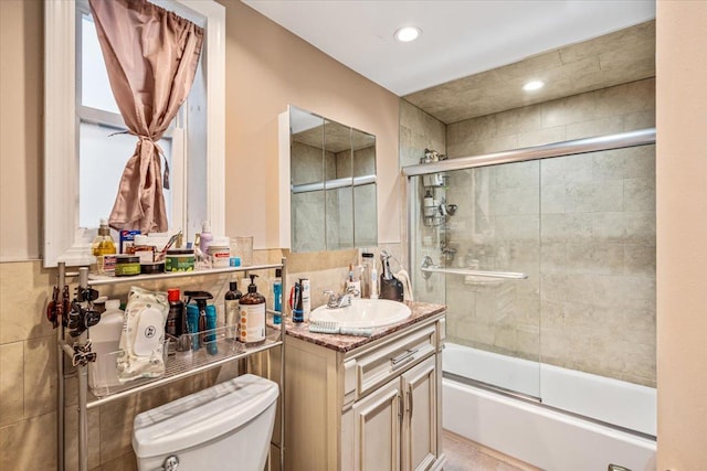 full bathroom with vanity, toilet, and enclosed tub / shower combo