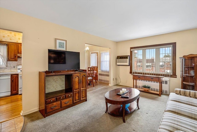 living room featuring a wall unit AC, radiator, light hardwood / wood-style flooring, and a chandelier