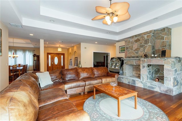 living room featuring hardwood / wood-style flooring, ceiling fan, and a raised ceiling