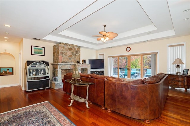 living room featuring a raised ceiling, ceiling fan, dark hardwood / wood-style flooring, and french doors