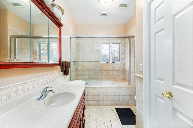 bathroom featuring shower / bath combination with glass door and vanity