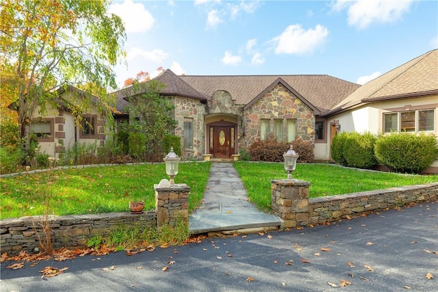 french provincial home with a front lawn