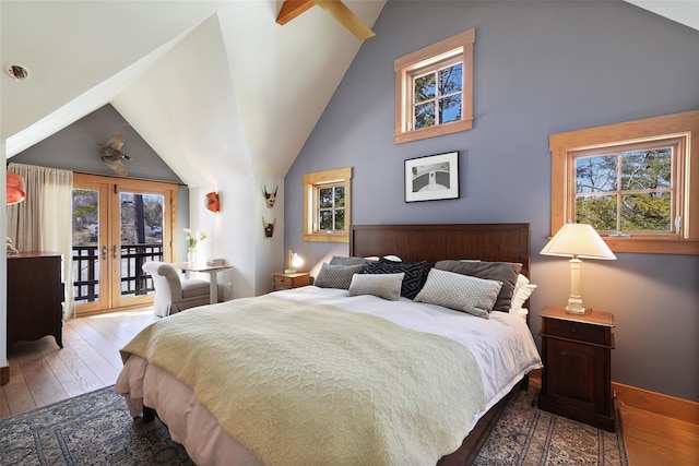 bedroom featuring access to exterior, wood-type flooring, multiple windows, and french doors