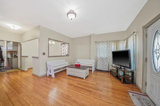 living area with light wood-type flooring and a chandelier