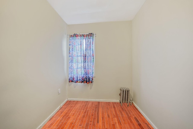 unfurnished room with radiator heating unit and light hardwood / wood-style floors