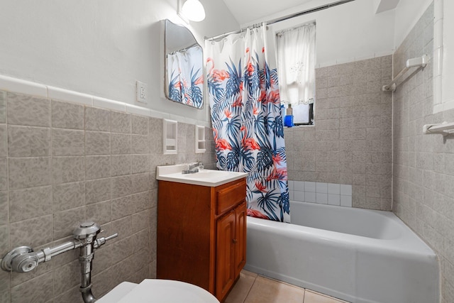 full bathroom featuring vanity, tile patterned floors, toilet, shower / bath combo with shower curtain, and tile walls