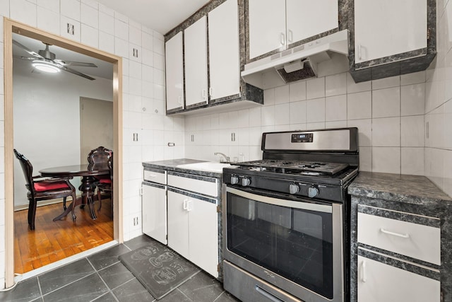 kitchen with white cabinets, gas range, ceiling fan, decorative backsplash, and dark hardwood / wood-style flooring