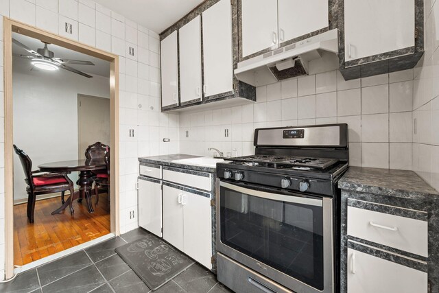 139-21 85th Dr Unit 3G, Briarwood, NY 11435 - kitchen featuring stainless steel gas range, under cabinet range hood, white cabinetry, and dark countertops