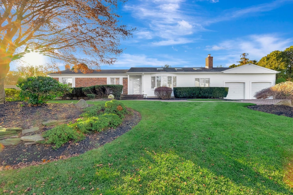 ranch-style home with a front yard and a garage