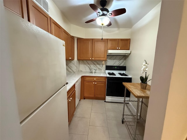 kitchen featuring ceiling fan, light tile patterned flooring, white appliances, and backsplash