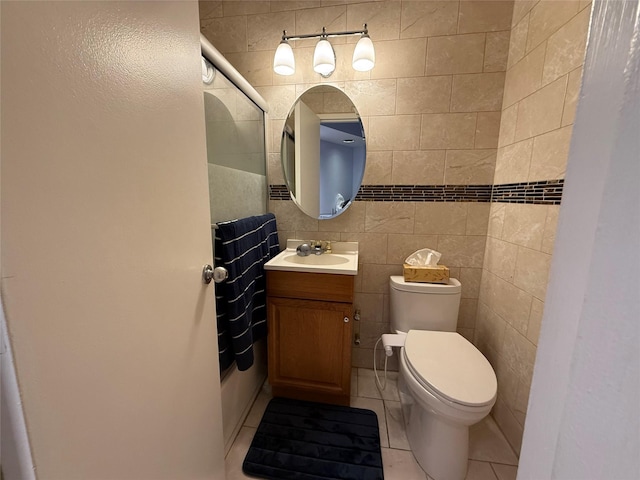 bathroom with tile patterned flooring, vanity, toilet, and tile walls