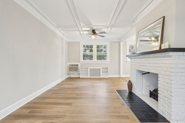 unfurnished living room with ceiling fan, coffered ceiling, a wall mounted AC, hardwood / wood-style floors, and a fireplace