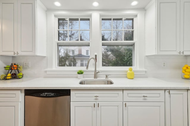 kitchen featuring dishwasher, white cabinets, tasteful backsplash, and sink