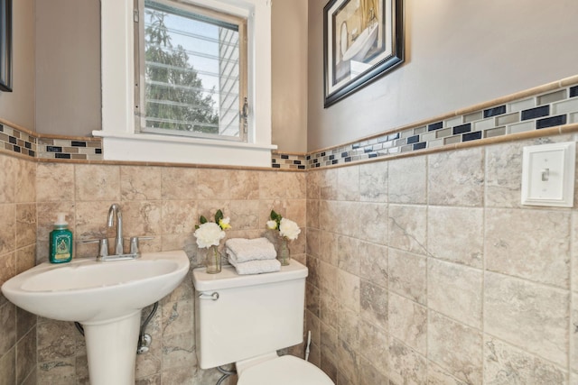 bathroom with toilet and tile walls