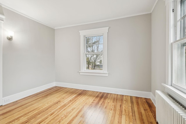 unfurnished room featuring wood-type flooring, radiator, and crown molding