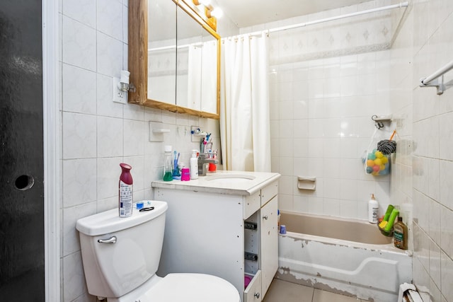 full bathroom featuring shower / bathtub combination with curtain, tile patterned floors, toilet, vanity, and tile walls