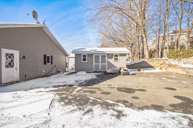 view of snow covered back of property