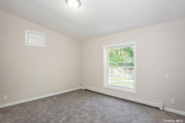 empty room with carpet flooring, vaulted ceiling, and a baseboard radiator