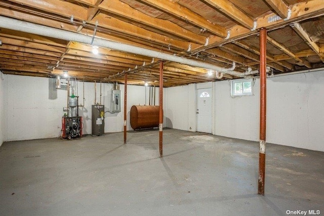 basement featuring electric panel and water heater