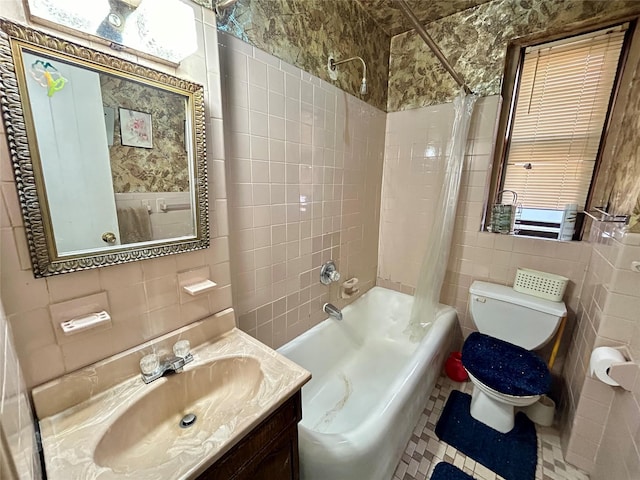 full bathroom featuring shower / bath combo, tile patterned flooring, toilet, vanity, and tile walls