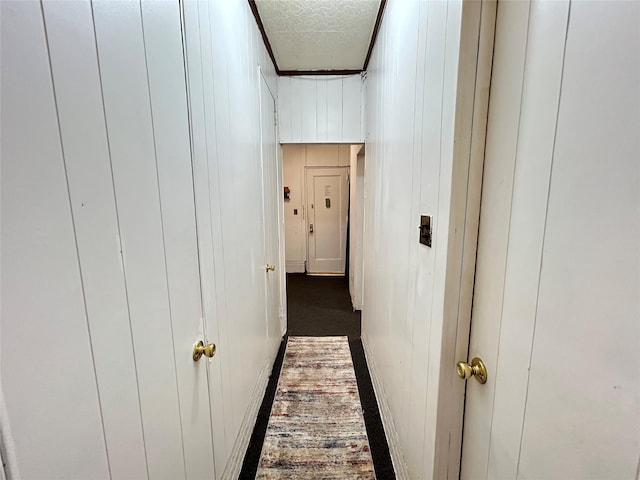 corridor with a textured ceiling and wooden walls