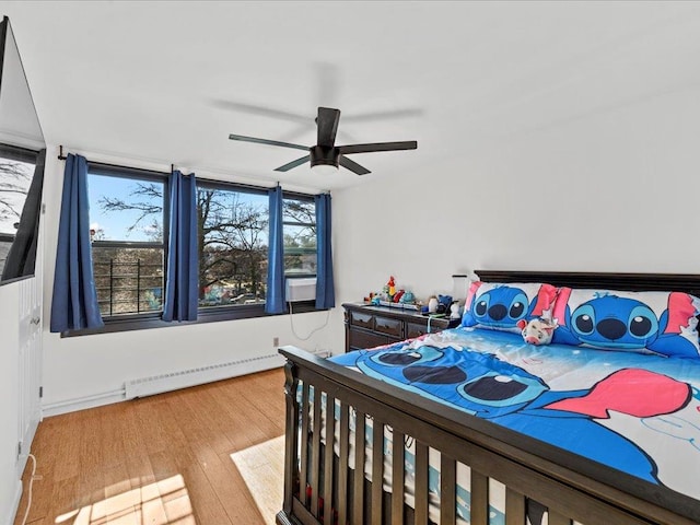 bedroom featuring baseboard heating, ceiling fan, and light wood-type flooring