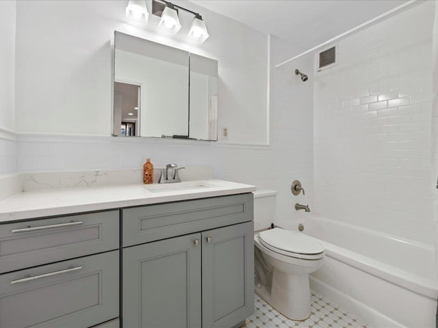 full bathroom featuring tile walls, toilet, vanity, and tiled shower / bath