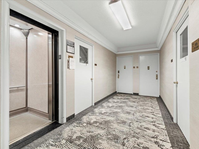 hallway with elevator, a textured ceiling, and crown molding