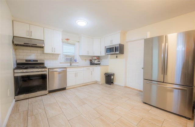 kitchen with white cabinets, decorative backsplash, sink, and stainless steel appliances