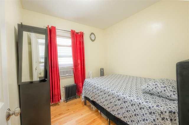 bedroom featuring wood-type flooring and radiator