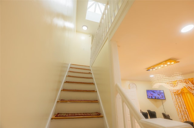 stairs with a notable chandelier