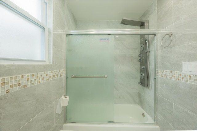 bathroom featuring shower / bath combination with glass door and plenty of natural light