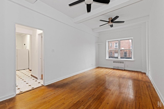 interior space featuring ceiling fan, beam ceiling, radiator, and light hardwood / wood-style flooring