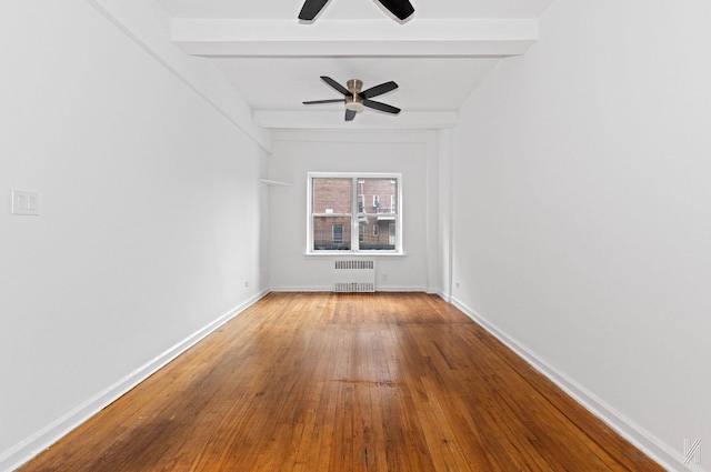 unfurnished room with hardwood / wood-style flooring, ceiling fan, beam ceiling, and radiator heating unit