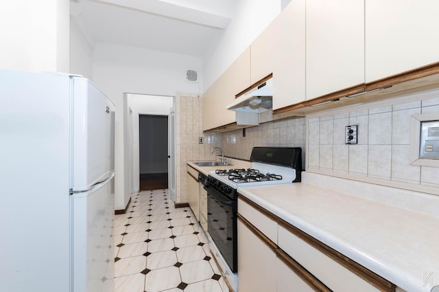 kitchen with decorative backsplash, white cabinetry, white appliances, and sink