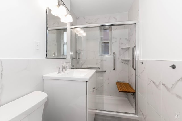 bathroom featuring vanity, toilet, tile walls, and walk in shower