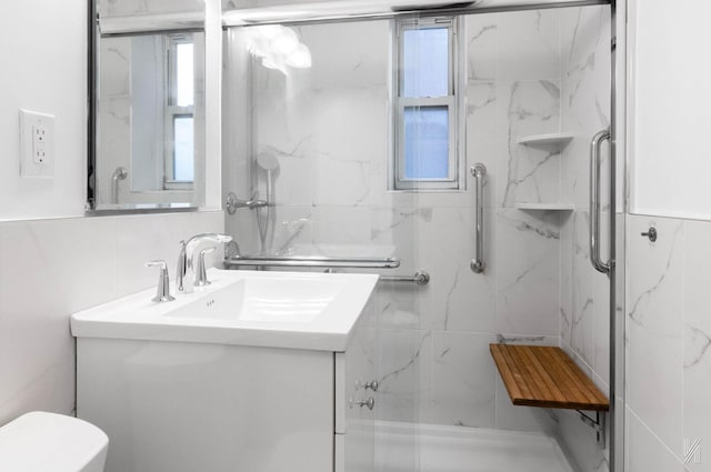 bathroom with backsplash, toilet, a shower with door, vanity, and tile walls