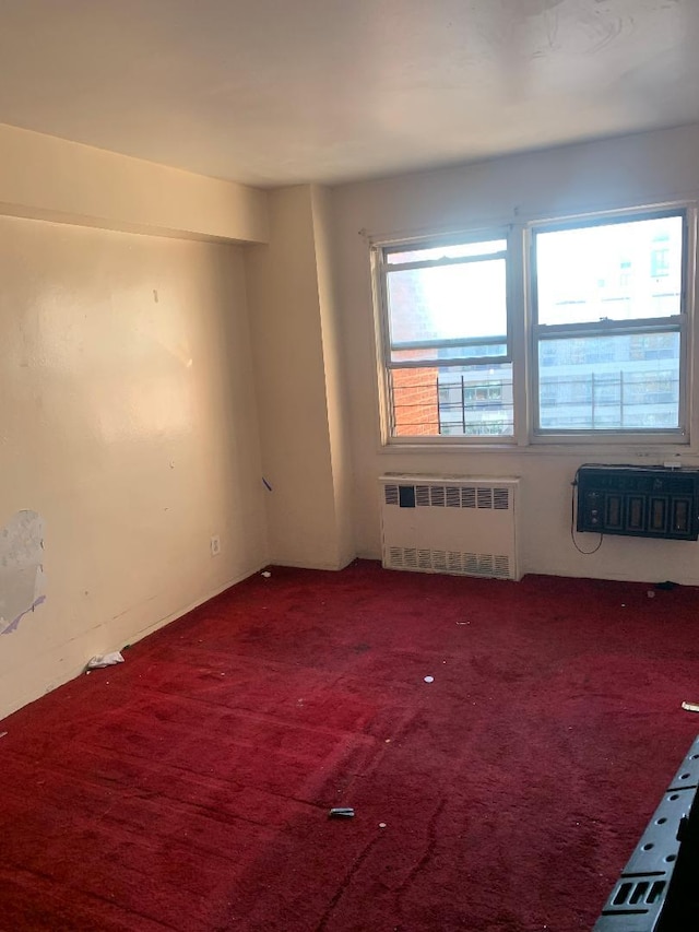 unfurnished room featuring carpet and radiator