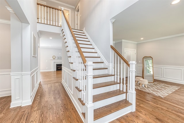 stairway featuring hardwood / wood-style flooring and crown molding