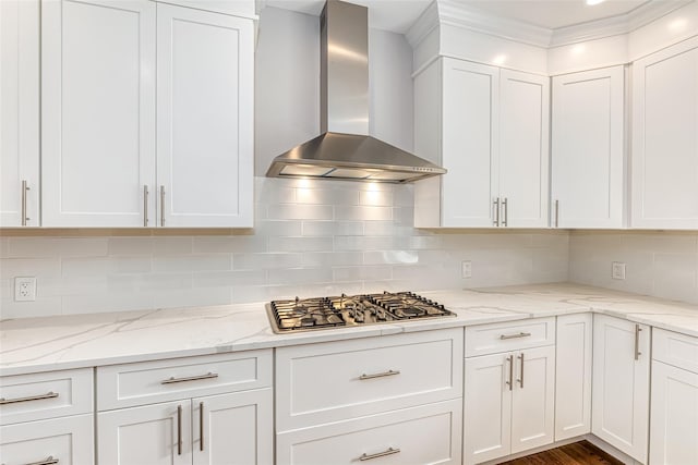 kitchen featuring backsplash, white cabinets, wall chimney exhaust hood, and stainless steel gas cooktop