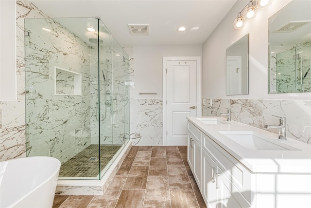 bathroom with vanity, tile walls, and independent shower and bath